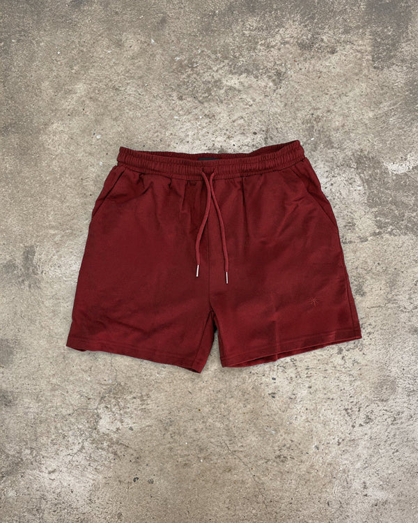 Maroon shorts on a textured gray surface