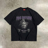 Black t-shirt with graphic design on a textured gray surface