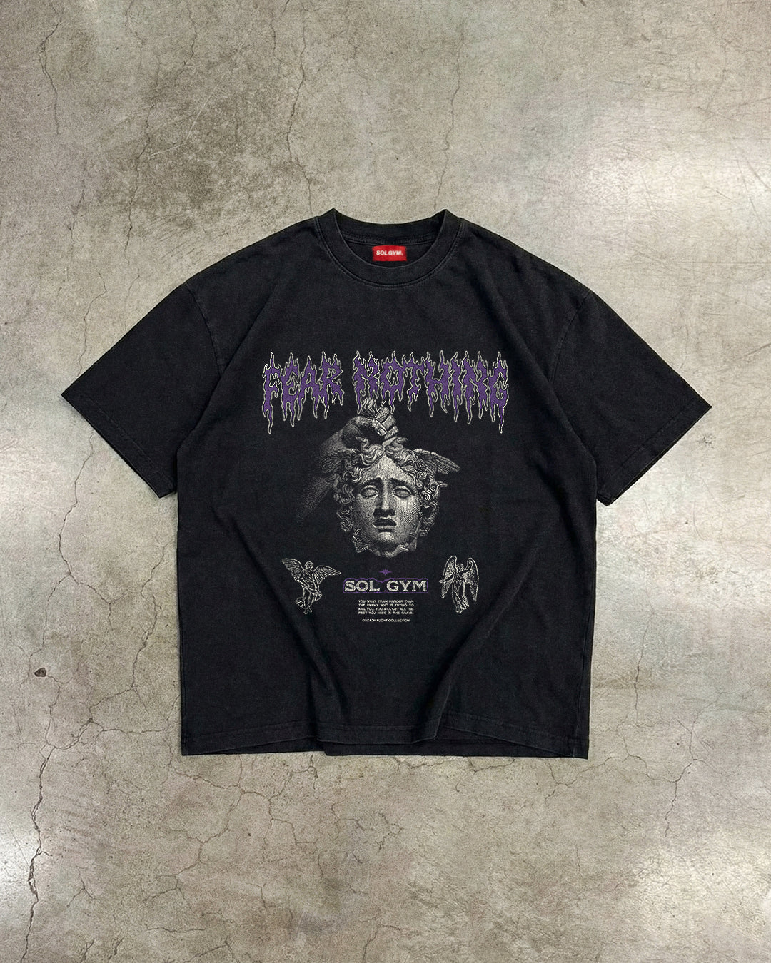 Black t-shirt with graphic design on a textured gray surface