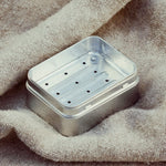 Metallic soap dish on a textured fabric background