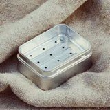 Metallic soap dish on a textured fabric background