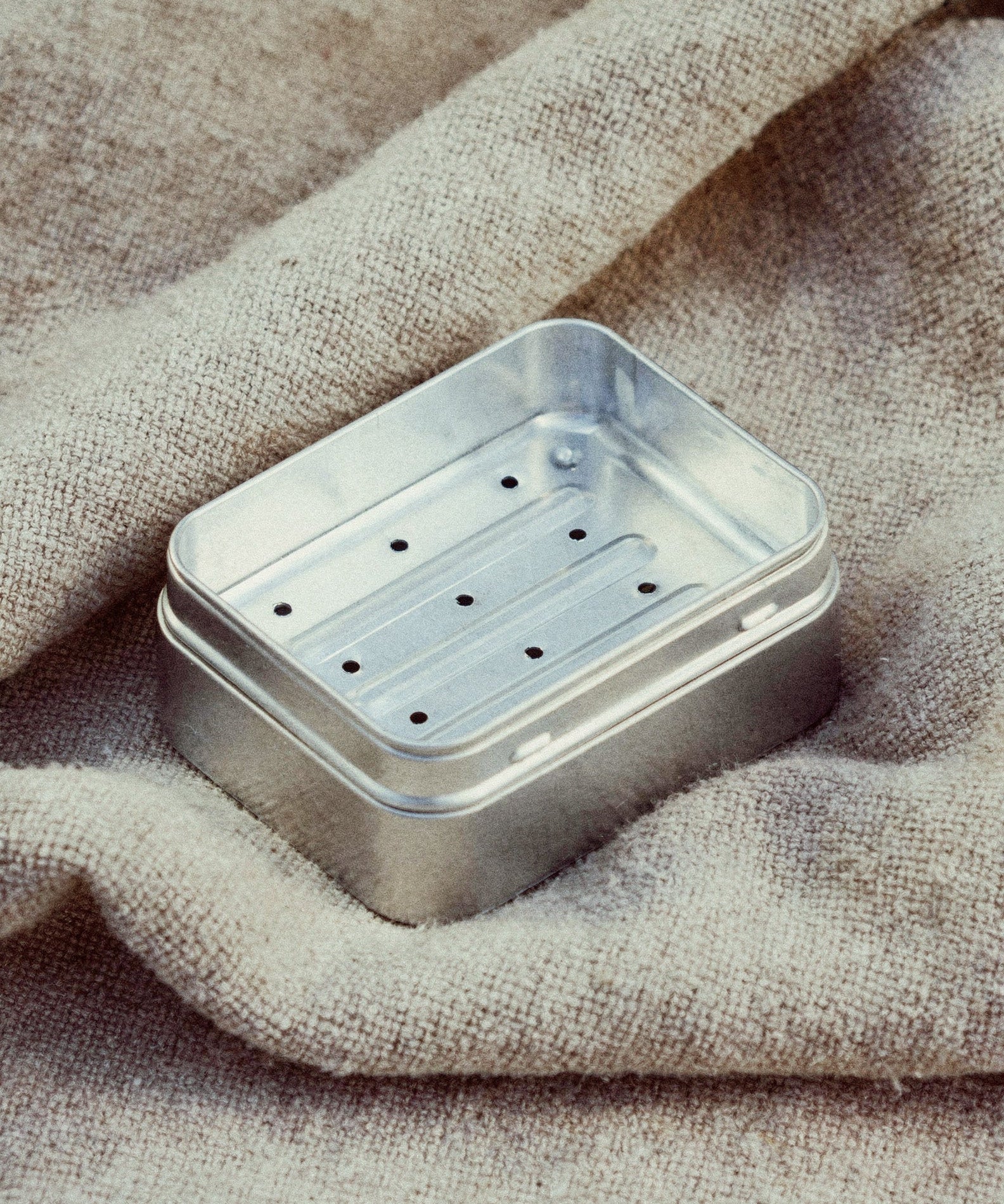 Metallic soap dish on a textured fabric background