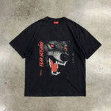 Black t-shirt with a wolf graphic and 'FEAR NOTHING' text on a textured surface